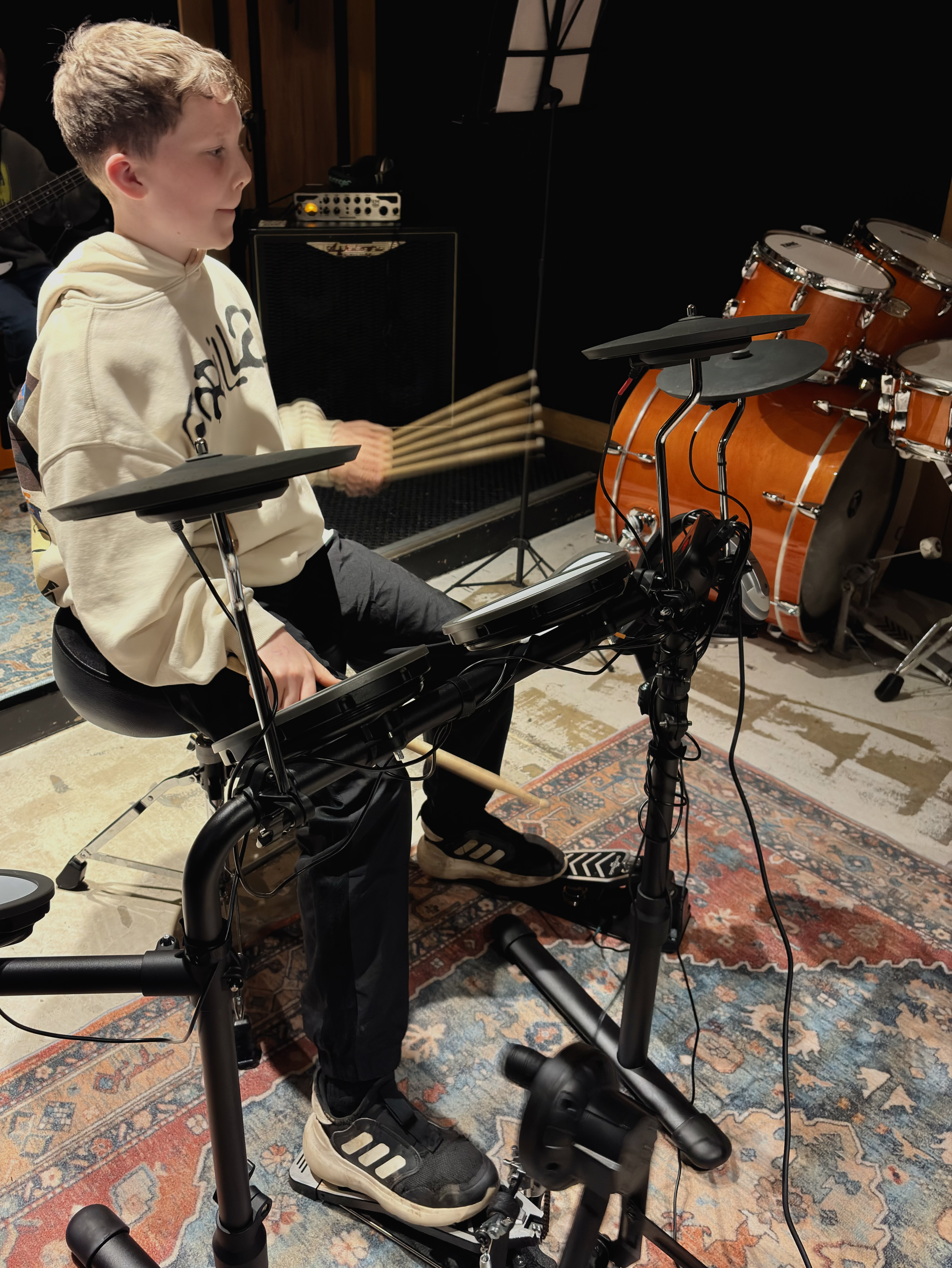 Child playing electronic drums in a Band Night session.