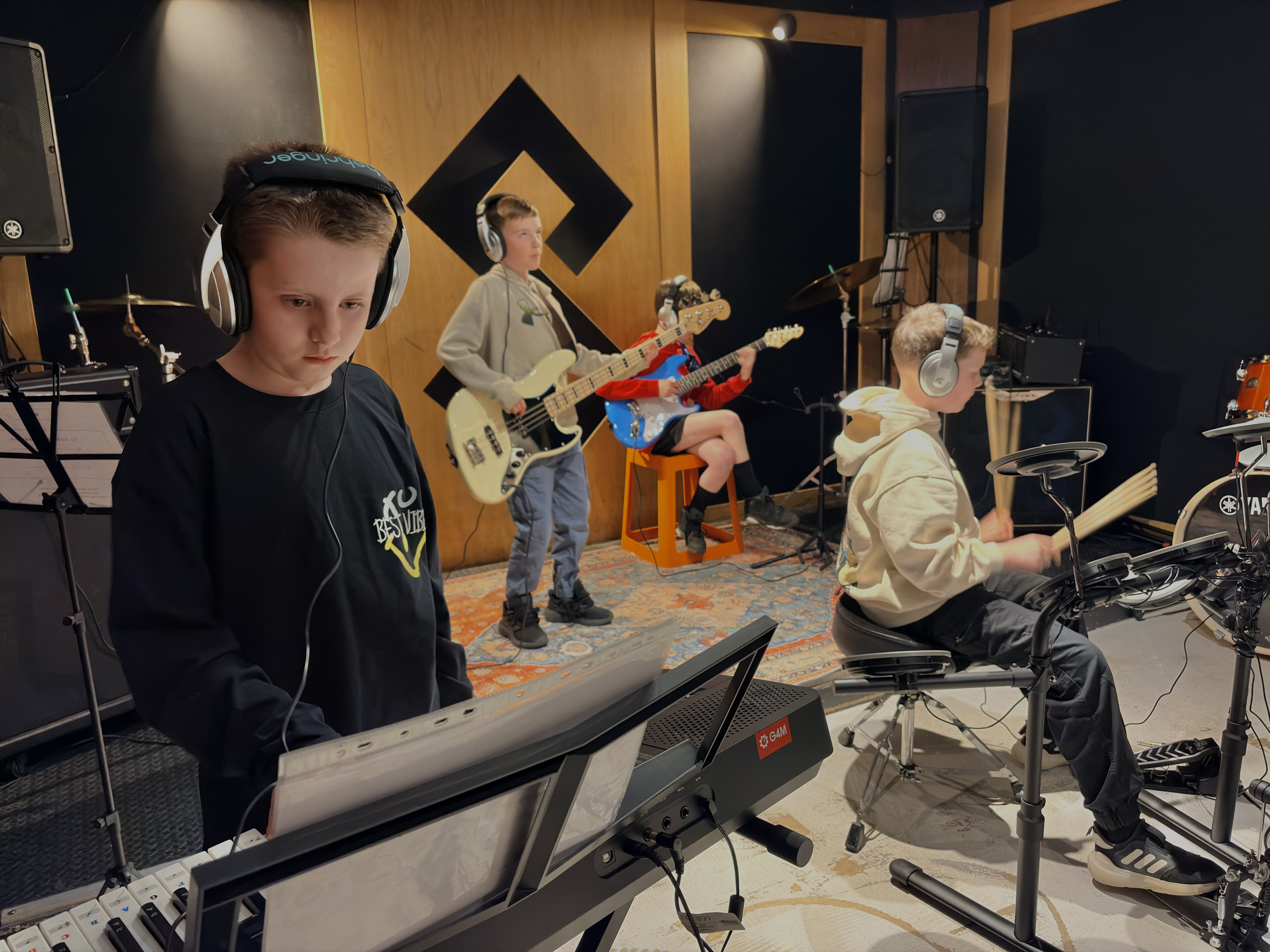 Children rehearsing together in a Band Night studio session with keyboards, bass and drums.